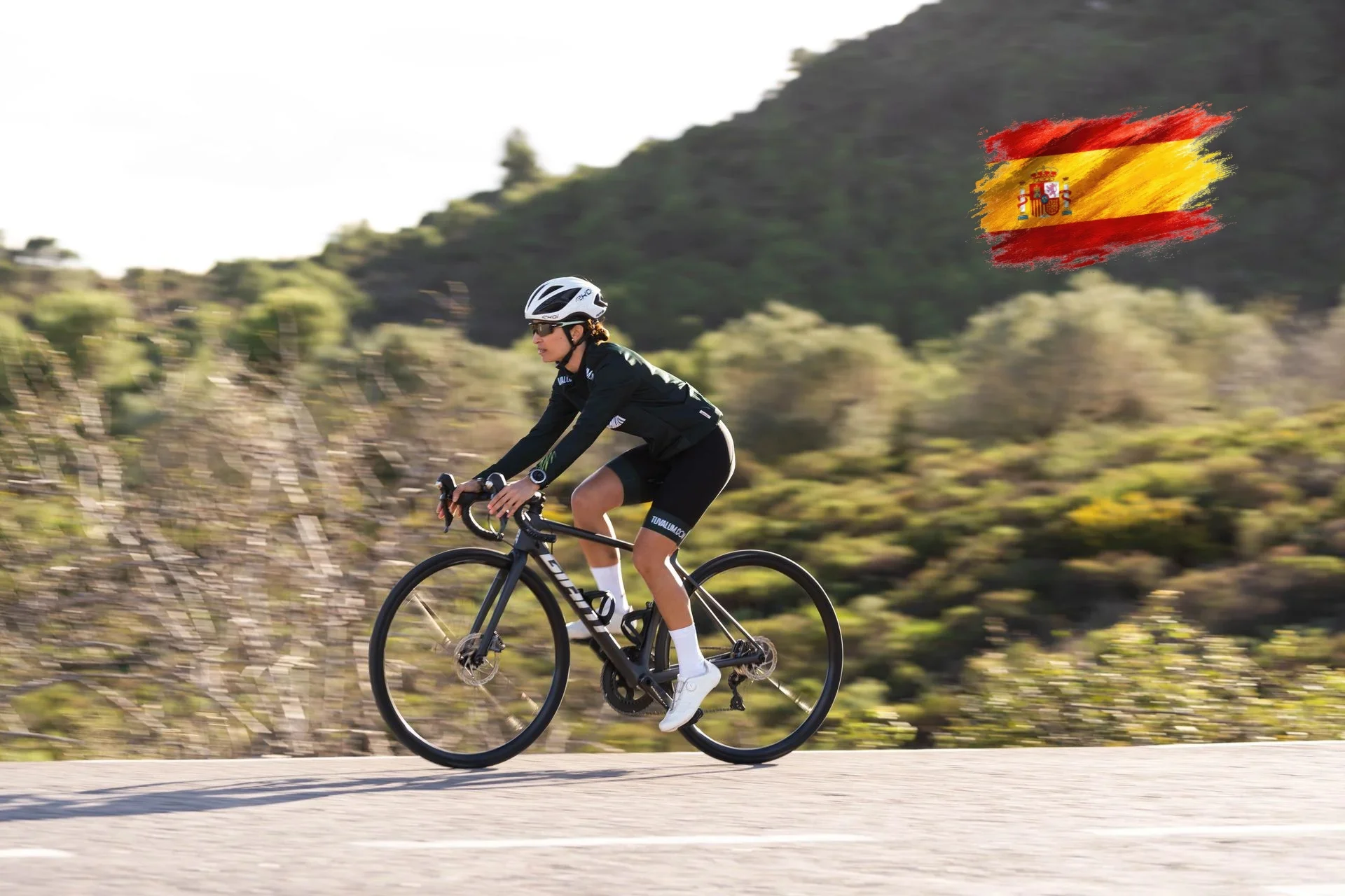 Female professional cyclist riding a road bike through the Spanish mountains Female professional cyclist riding a road bike through the Spanish mountains